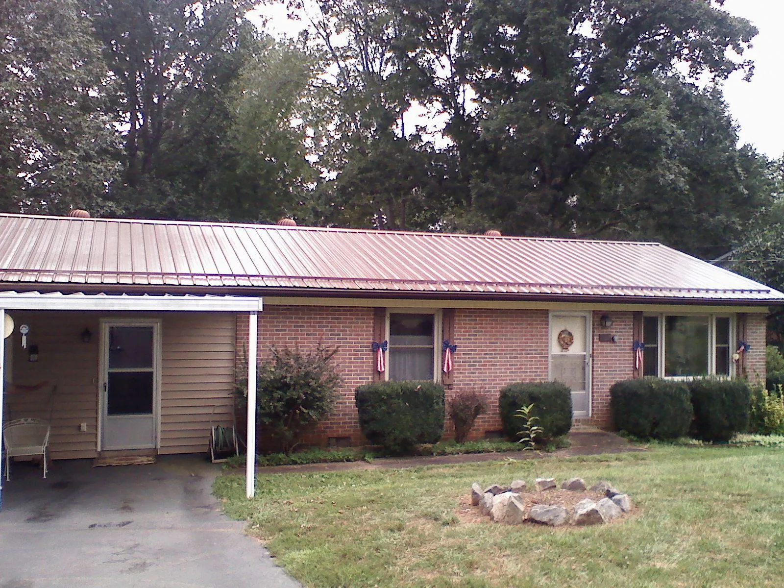 Bronze metal roof and carport on a brick ranch home — Roof Repair work by our crew in Bee